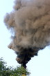 Smoking factory stack against a blue sky
