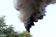 Smoking factory stack against a blue sky