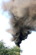 Smoking factory stack against a blue sky