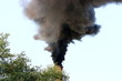 Smoking factory stack against a blue sky
