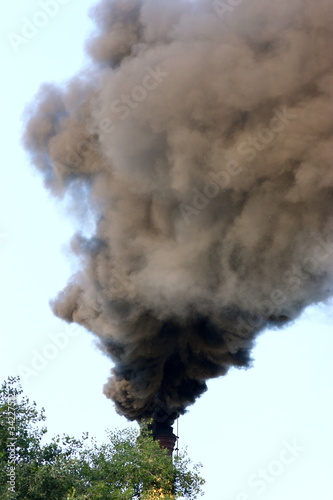 Photo: Smoking factory stack against a blue sky Smoking factory stack against a blue sky