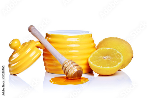 Photo: Honey and lemon isolated on a white background. Honey and lemon isolated on a white background.