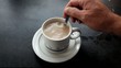 Cup with a teabag being stirred.