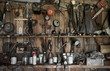 many different old tools hanging on a barn wall