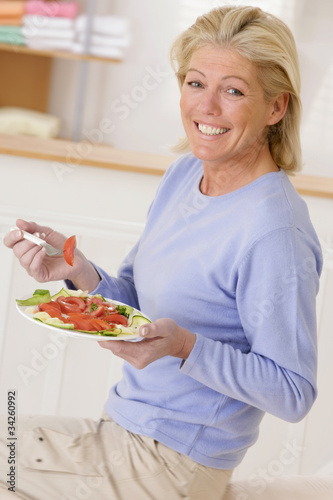 Photo: Femme senior avec une assiette de crudités Femme senior avec une assiette de crudités