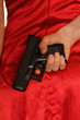 Girl in a red dress holding a gun behind her back Girl in a red dress holding a gun behind her back