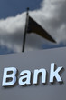Bank sign on background of sky and flag
