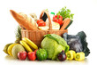Groceries in wicker basket isolated on white Groceries in wicker basket isolated on white