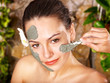 Young woman having clay body mask. Young woman having clay body mask.
