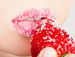woman's mouth with red strawberry covered with sugar woman's mouth with red strawberry covered with sugar