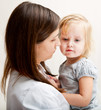 a mother is holding a sick girl.