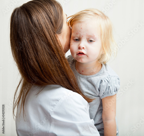 Photo: a mother is holding a sick girl. a mother is holding a sick girl.