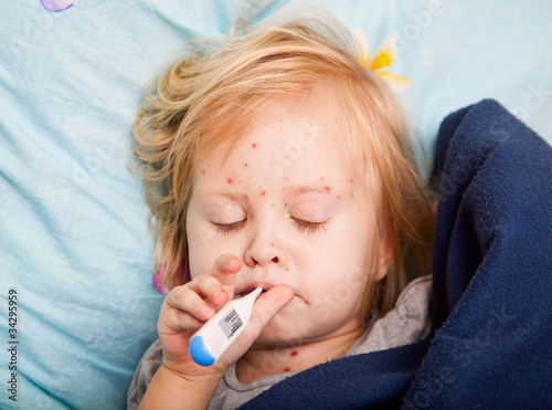 Photo: a sick girl is measuring the temperature a sick girl is measuring the temperature