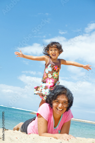 Photo: ethnic girl fun with mother on tropical beach ethnic girl fun with mother on tropical beach