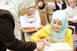 Female teacher helping children in classroom