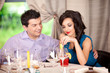 man flirting, woman annoyed at restaurant table