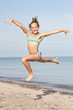 Foto: Mädchen springt am Strand Mädchen springt am Strand
