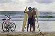 newlywed couple at the beach with surfboards and bikes