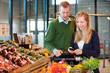 Photo: Couple Buying Groceries with List on Phone Couple Buying Groceries with List on Phone