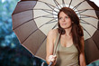Beautiful woman holding umbrella out in the rain