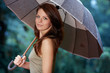Beautiful woman holding umbrella out in the rain