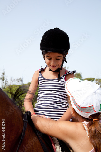 Photo: bambina che sale a cavallo bambina che sale a cavallo