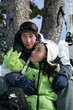 Teenage couple sitting on a ski slope