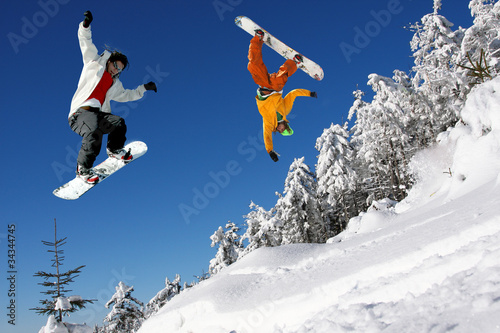 Photo: Snowboarders jumping against blue sky Snowboarders jumping against blue sky