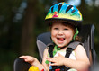 Photo: Little girl in the seat bicycle with a helmet on his head Little girl in the seat bicycle with a helmet on his head