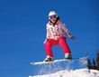 Snowboarder jumping through air with  blue sky in background