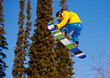 Snowboarder jumping through air with  blue sky in background