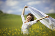 Smiling woman with white piece of cloth in wind Smiling woman with white piece of cloth in wind