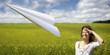 Woman looking after ascending paper plane Woman looking after ascending paper plane