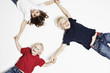 Smiling children on floor holding hands Smiling children on floor holding hands