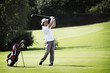 Golfer pitching at golf course.