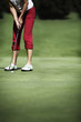 Photo: Female golfer putting Female golfer putting