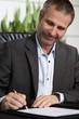 Happy business person signing a contract.