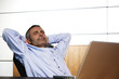 Happy manager relaxing in office chair.
