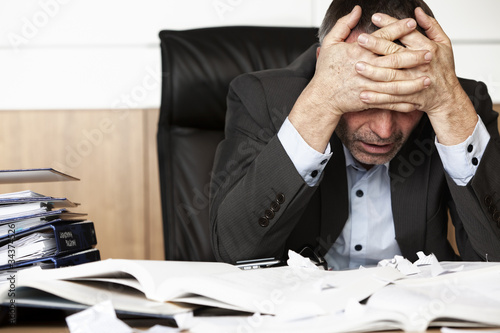 Foto: Frustrated office manager overloaded with work. Frustrated office manager overloaded with work.