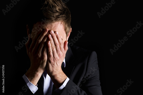 Photo: Desperate businessman covering his face. Desperate businessman covering his face.