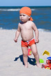 young boy playing in the sand on the beach