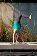 woman doing yoga outdoors in three leg downward facing dog pose