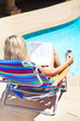 The woman with newspaper near the pool The woman with newspaper near the pool