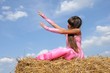A girl in a field stretching to the sky