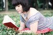 Attractive girl, lying on a grass and reading Attractive girl, lying on a grass and reading