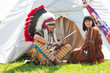 North American Indians sit at a wigwam