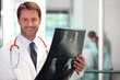 Happy doctor looking at x-ray image of hand