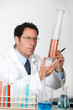 Laboratory technician examining liquid in a graduated cylinder