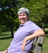 middle-aged woman on bench smiling
