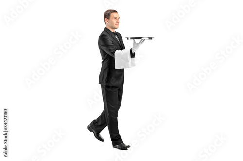 Foto: Young butler with bow tie carrying a tray Young butler with bow tie carrying a tray
